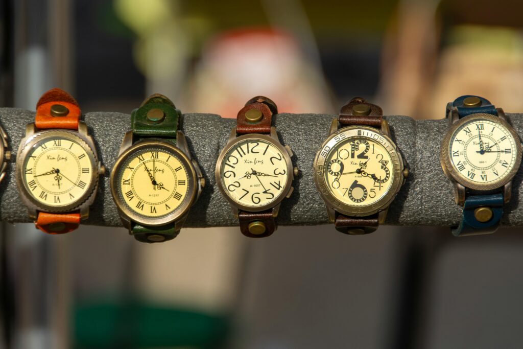 Assorted vintage watches with leather straps on a display rack.